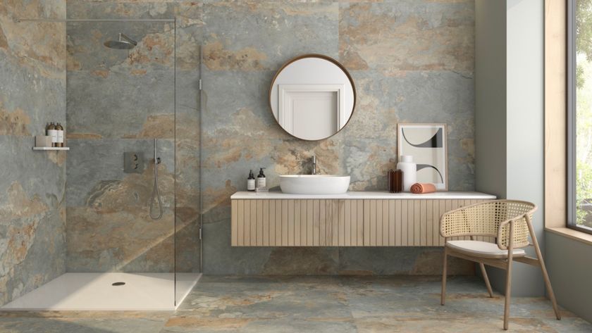 grey bathroom with grey stone large format tiles, wall mounted wooden vanity and walk in shower