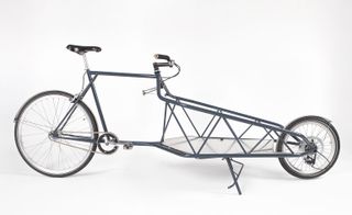 Elongated metal bike frame with storage area at the front