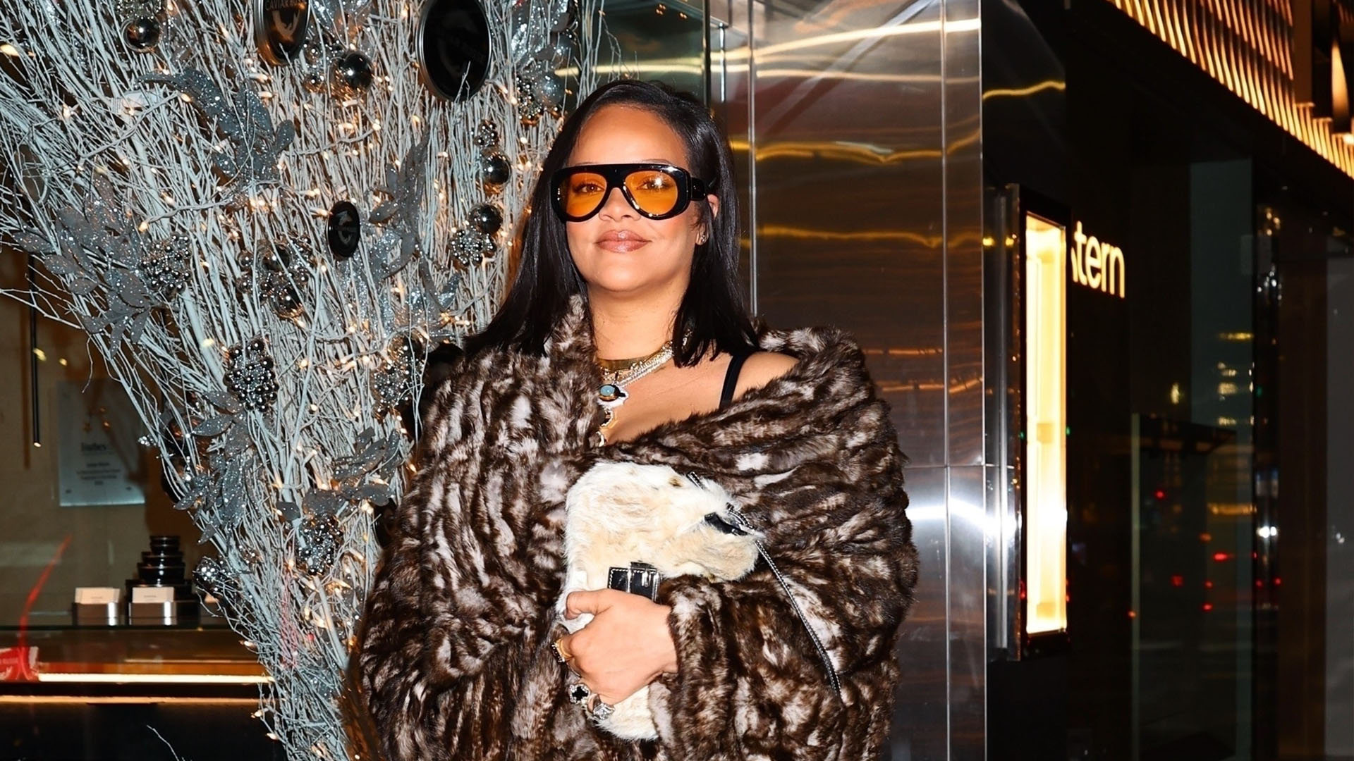 Rihanna wearing a fur coat, brown Loewe pants, and croc print heels