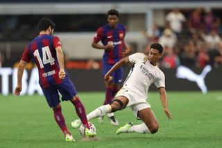 Jude Bellingham #5 of Real Madrid and Ilkay Gündogan #14 of Barcelona battle for the ball during the pre-season friendly match between FC Barcelona and Real Madrid at AT&T Stadium on July 29, 2023 in Arlington, Texas.