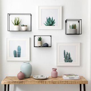 room with white wall and picture frames and pots and table