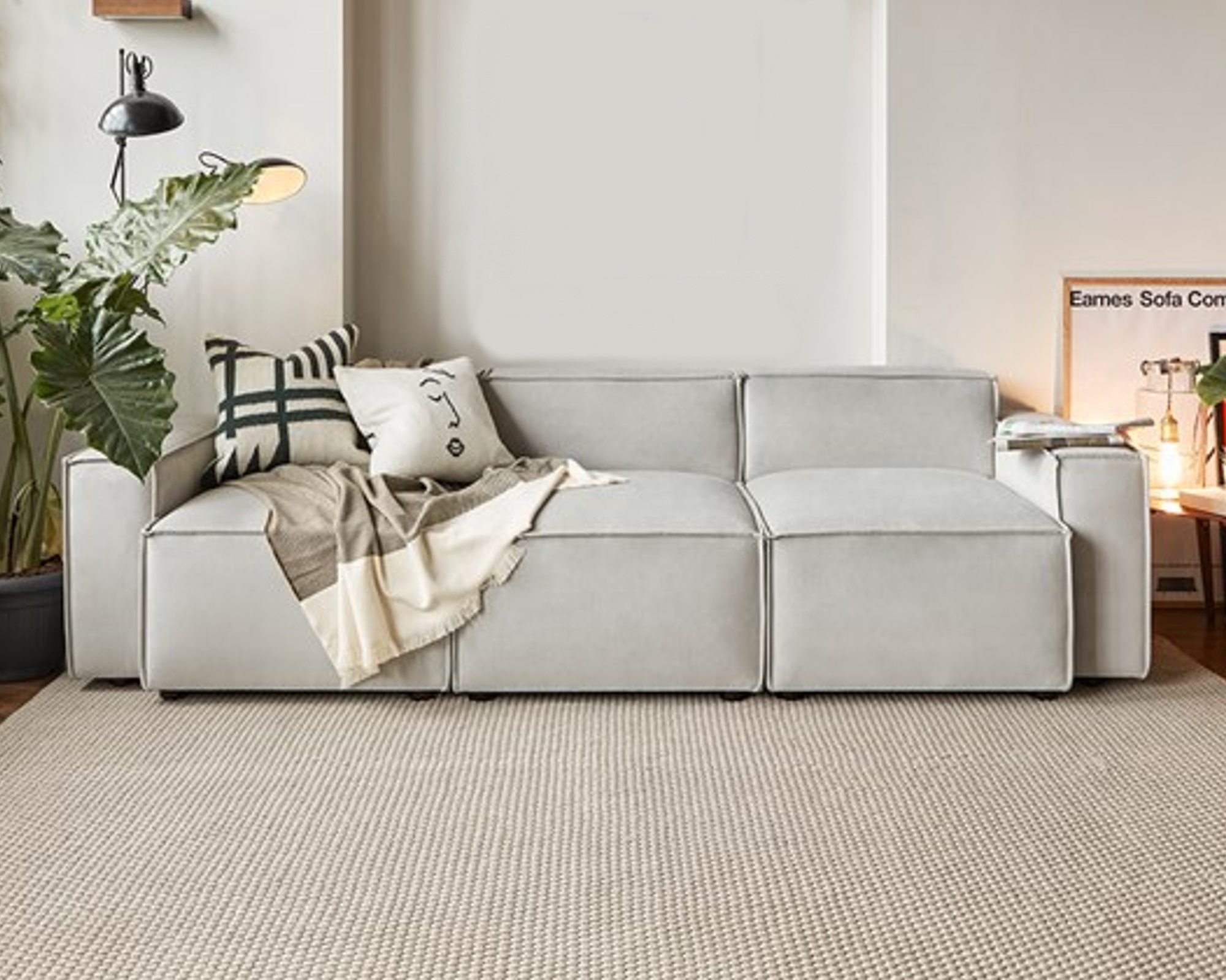 A pale grey contemporary modular sofa in a high-ceilinged living room