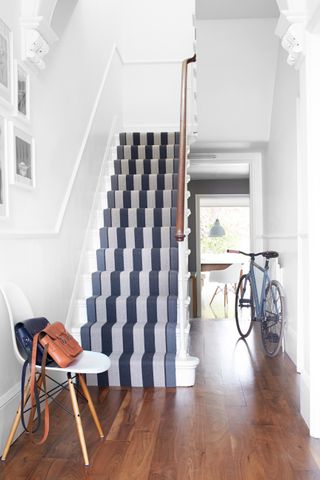 staircase in fresh looking hallway with blue striped runner by roger oates design