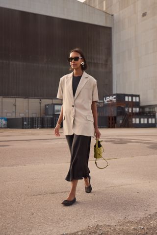 woman wearing short-sleeved blazer, skirt, top, and ballet flats