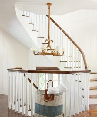 A white entryway with a chandelier and wooden railings