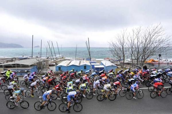 The peloton rolls along by the sea.