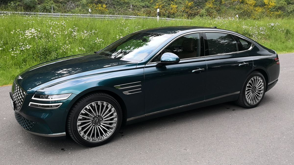 Angled side view of green Genesis Electrified G80 EV in a car park