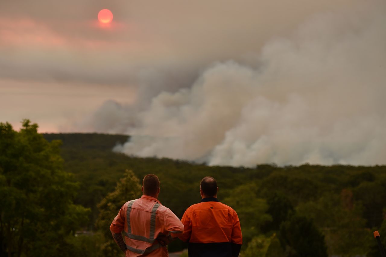 TOPSHOT - Residents watch a large bushfire as seen from Bargo, 150km southwest of Sydney, on December 19, 2019. - A state of emergency was declared in Australia&amp;#039;s most populated region on Dec