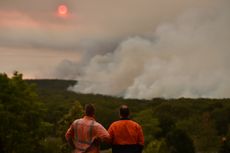 TOPSHOT - Residents watch a large bushfire as seen from Bargo, 150km southwest of Sydney, on December 19, 2019. - A state of emergency was declared in Australia's most populated region on Dec