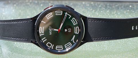 En svart Samsung Galaxy Watch 6 Classic 47mm ligger på ett ljust bord.