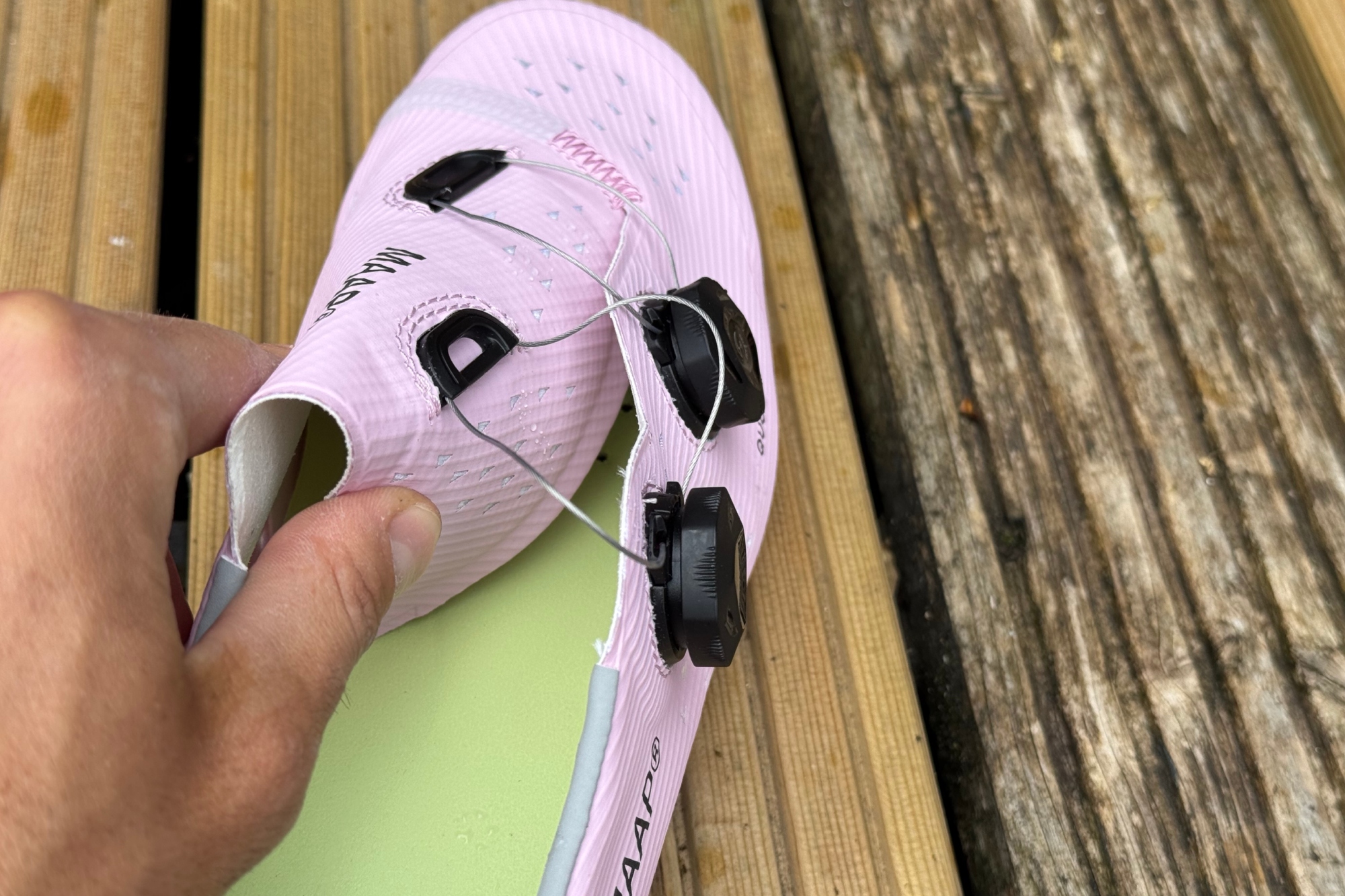MAAP x QUOC M3 shoes with a hand holding the wraparound tongue back to display the shoe inner