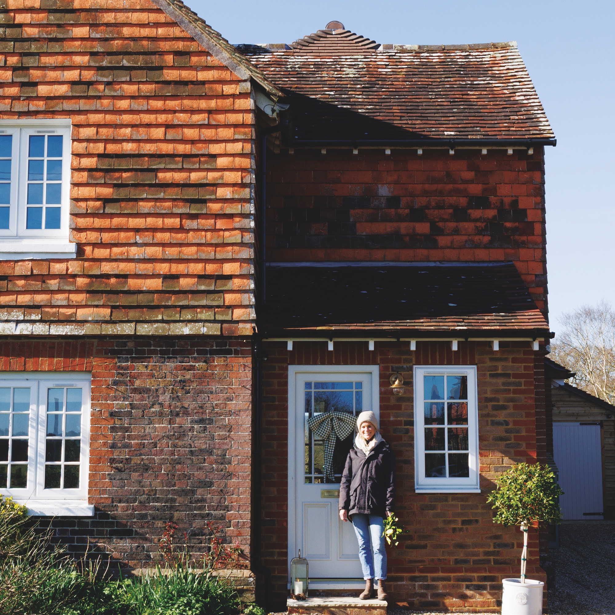 exterior of edwardian cottage with peg tile and brick facade and white framed windows and door