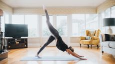 Woman doing three-legged dog on a yoga mat