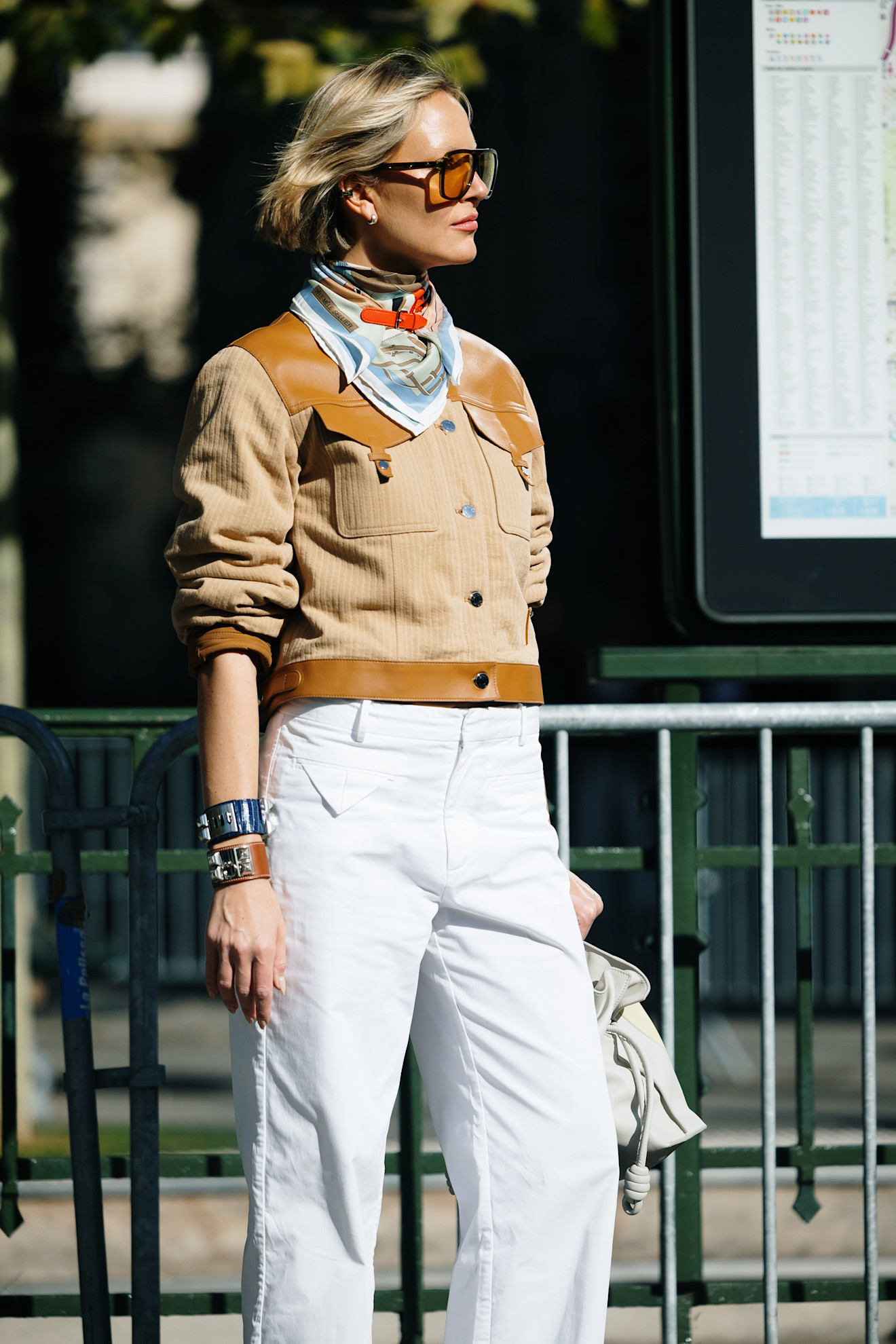 woman wearing a silk scarf and a suede bomber jacket in Paris