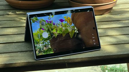 The Samsung Galaxy Z Fold 8 on a wooden table, showing a camera viewfinder.