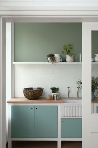 green and white kitchen with two shades of green wooden worktop freestanding units