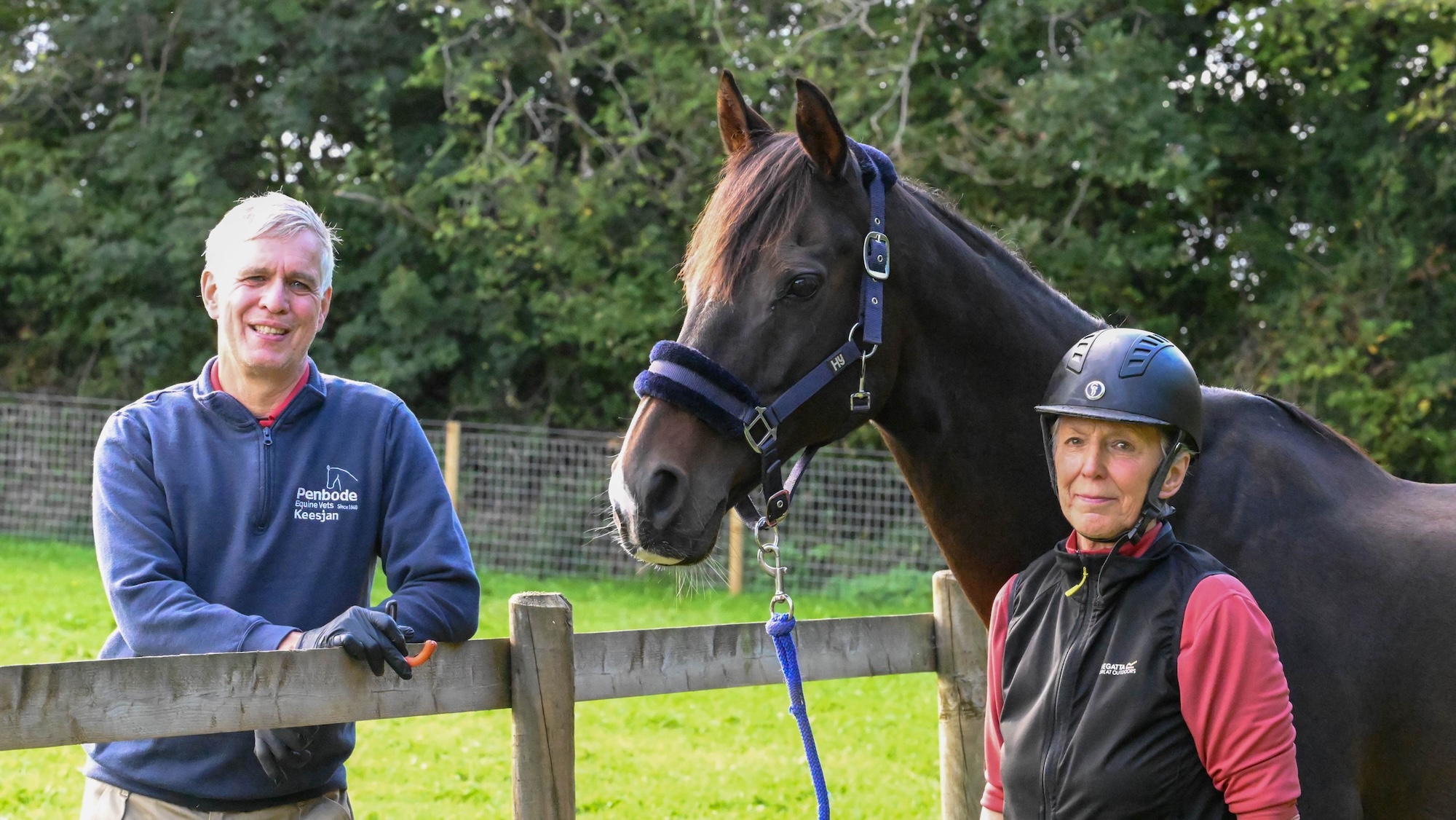 Bay gelding Baz standing with his owner and vet