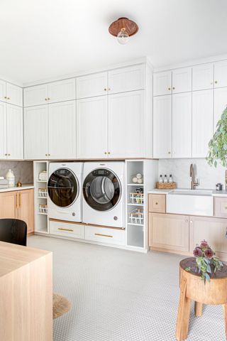 a laundry room with bespoke built ins to raise a washer dryer