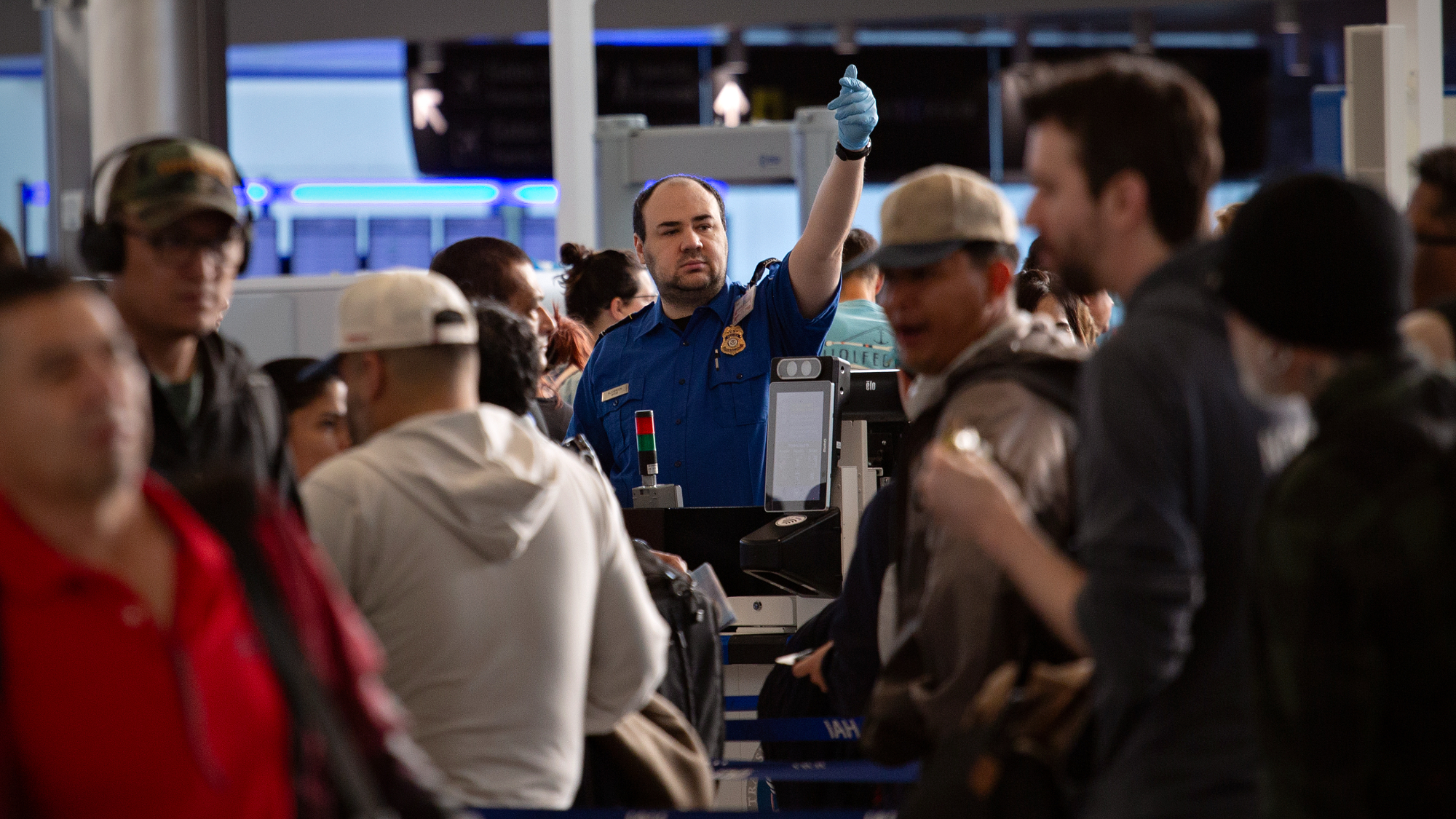 TSA agent waves up next passenger