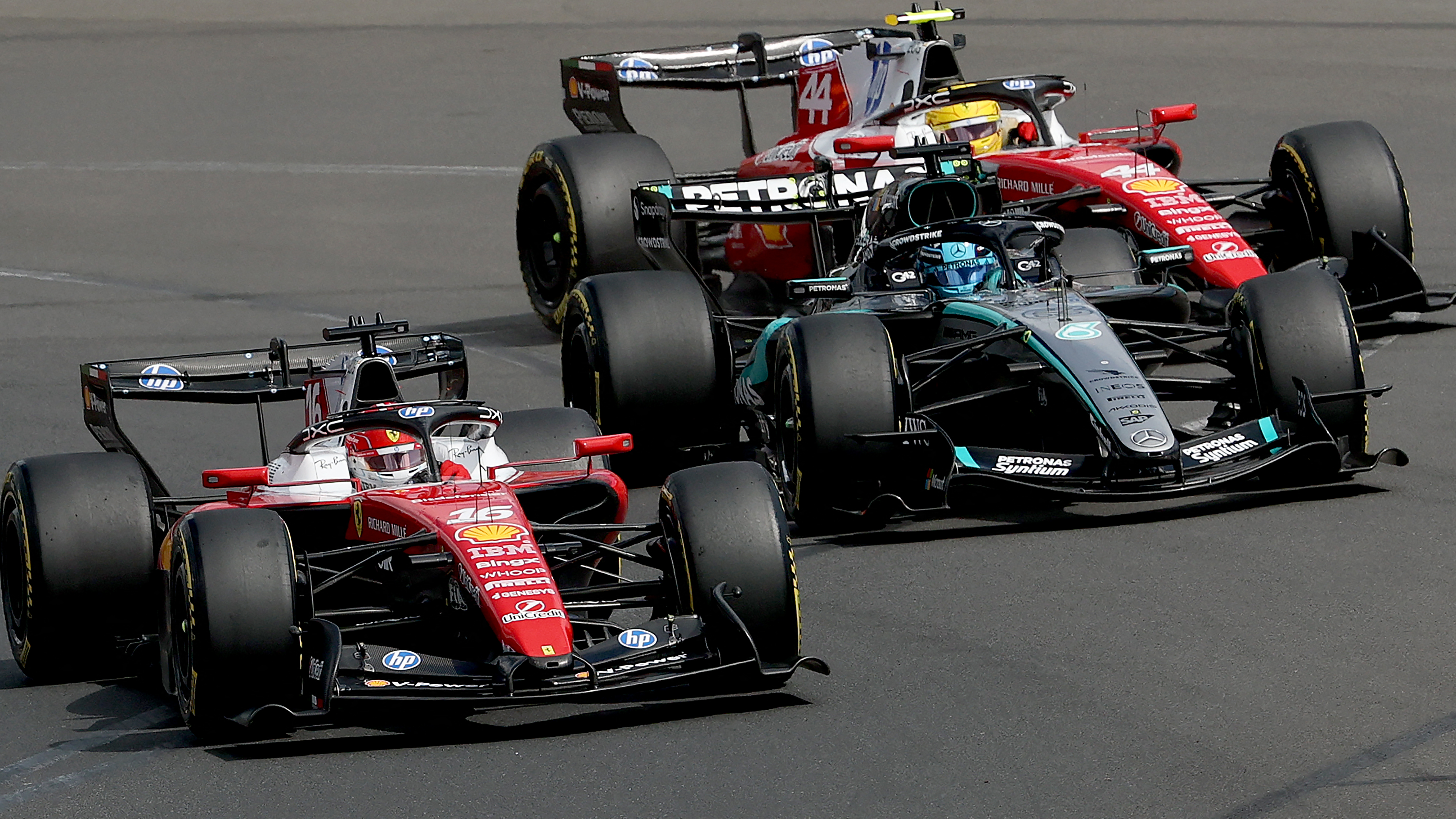 Ferrari's Monegasque driver Charles Leclerc (L) competes with Mercedes' British driver George Russell (C) and Ferrari's British driver Lewis Hamilton