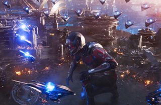 A still image from Ant-Man and the Wasp: Quantumania showing a gargantuan Ant-Man fighting off spaceships.