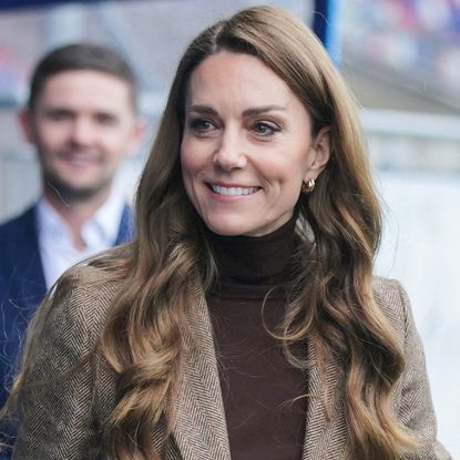 Princess Kate wearing a brown turtleneck and smiling