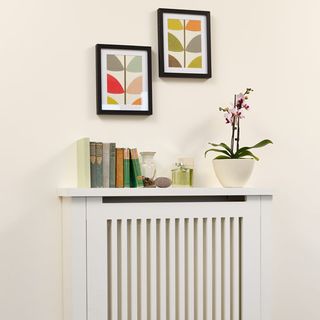 white wall with white wall table frames on wall and books