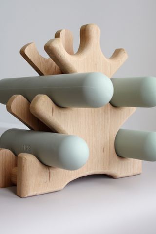 Blue hand weights on a wooden stand