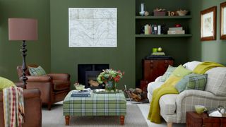 forest green living room with sage green accessories on neutral colored sofa to show key interior design trends 2022