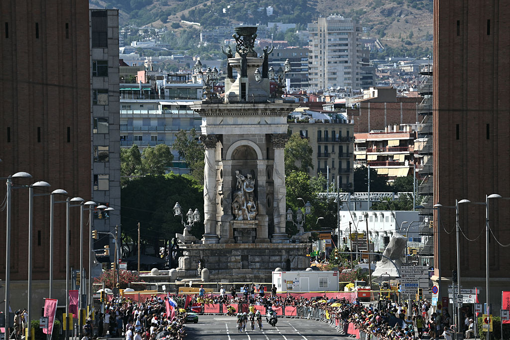The team Caja Rural-Seguros RGA cycles next to the Venetian Towers at the Pla&amp;ccedil;a d'Espanya during the 1st stage of the 113th edition of the Tour de France cycling race, a 19,6 km team time trial stage in and around Barcelona in northeastern Spain, on July 4, 2026. (Photo by Jeff PACHOUD / AFP)