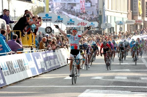 Andr&eacute; Greipel (Omega Pharma-Lotto) celebrates his victory while runner-up Lieuwe Westra (Vacansoleil-DCM) looks back at a charging peloton.