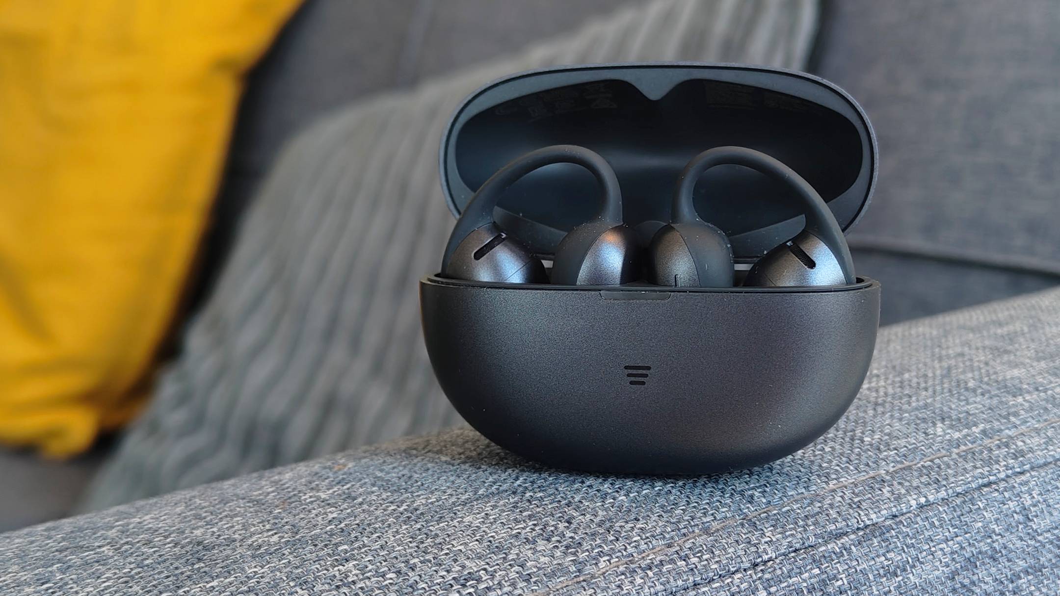 The Shokz OpenDots Air case, with the lid open and two earbuds visible.