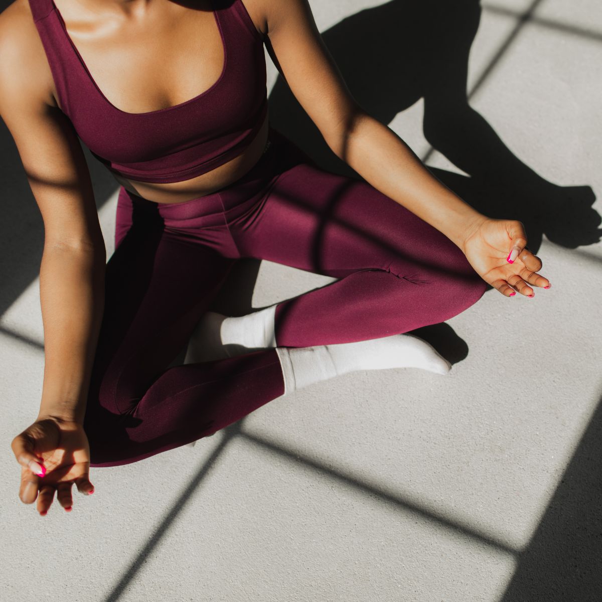 How to balance your hormones: A woman doing yoga at home in the sunshine