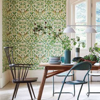 A bright dining room with green botanical print wallpaper