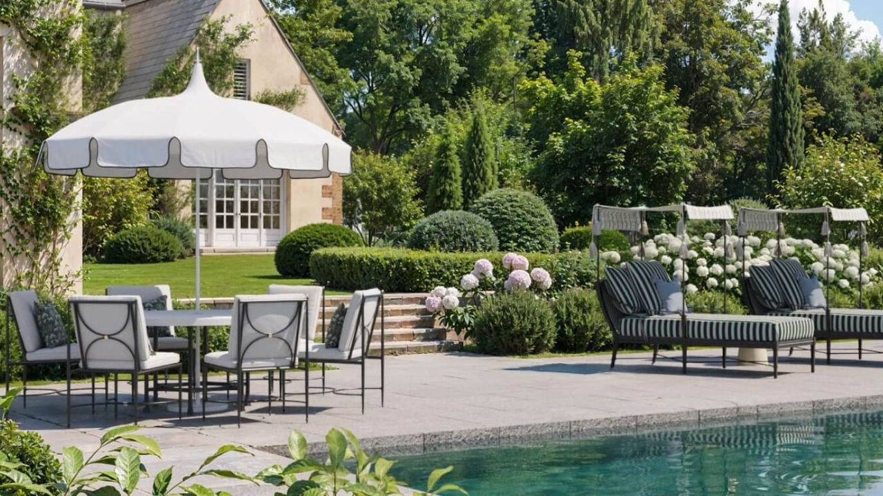 kathy kuo home outdoor poolside lookbook shot with striped pool loungers and a round table with patio umbrella and chairs