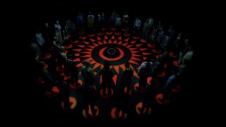 A group of people standing in an ominous circle in Circle