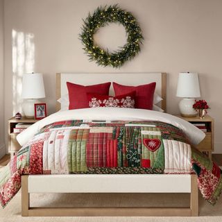 Holiday Love Reversible Quilt on a bed against a cream wall.