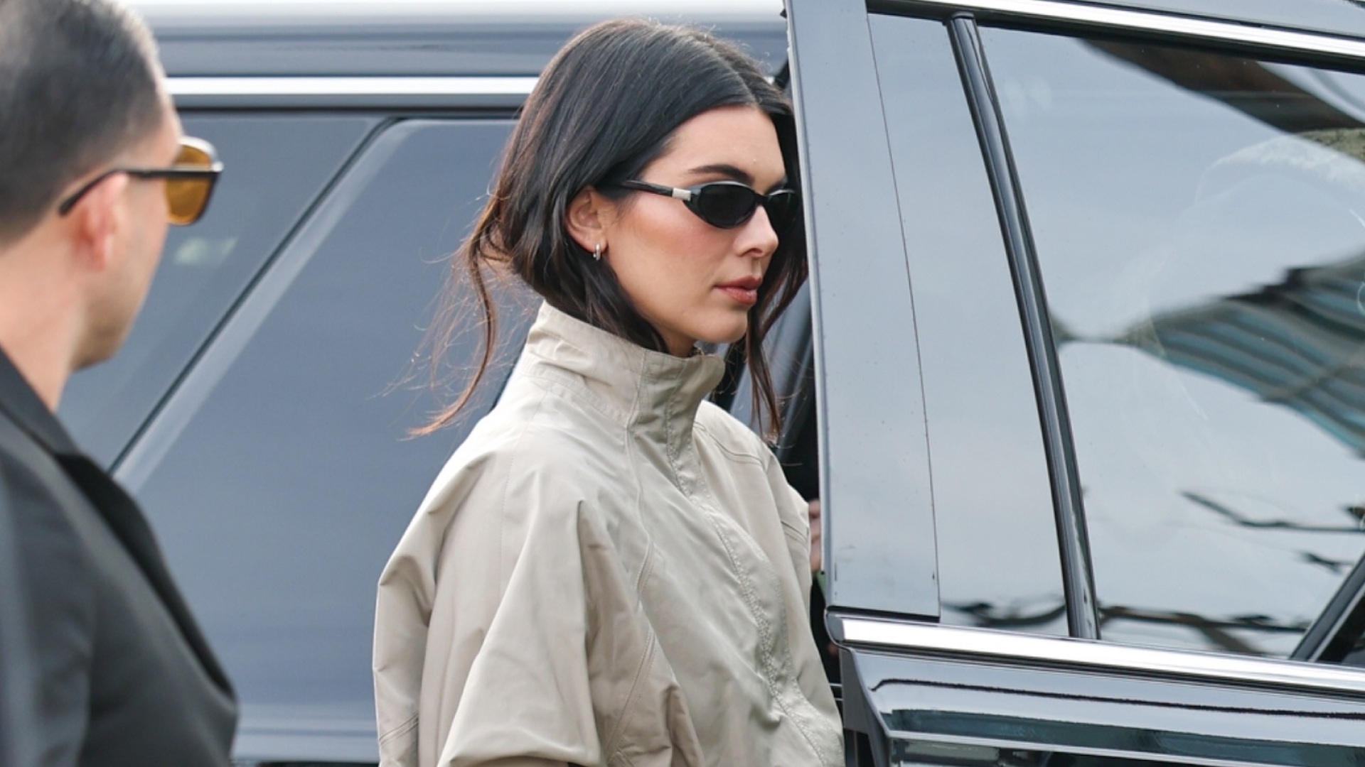Kendall Jenner attends the 2026 Fanatics Super Bowl Party at Pier 48 in San Francisco, California wearing black capri pants, thong mules, and a track jacket