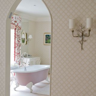 En-suite bathroom with pink freestanding bath and wool carpet