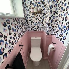 small downstairs loo with pink wall panelling and animal print wallpaper