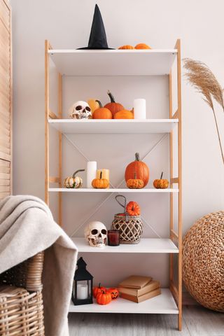 An open shelving unit decorated with pumpkins and other halloween decorations