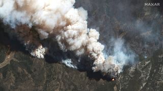 This satellite image shows a natural color view of wildfires raging at Hermit's Peak (near Las Vegas) on May 12, 2022.