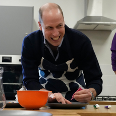Prince William, Prince Of Wales smiles as he looks up while decorating biscuits during his visit to WEST, a new OnSide Youth Zone WEST on March 14, 2024 in London, England.