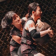 two women (kim hye-bin and kim dam-bi) wrestle over a ball in an octagon, in 'physical 100' season 2