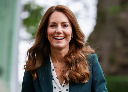 Kate Middleton smiling wearing a green jacket