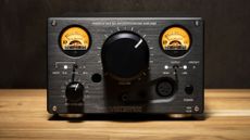 Violectric HPA V324 headphone amp on a wooden surface with a black background