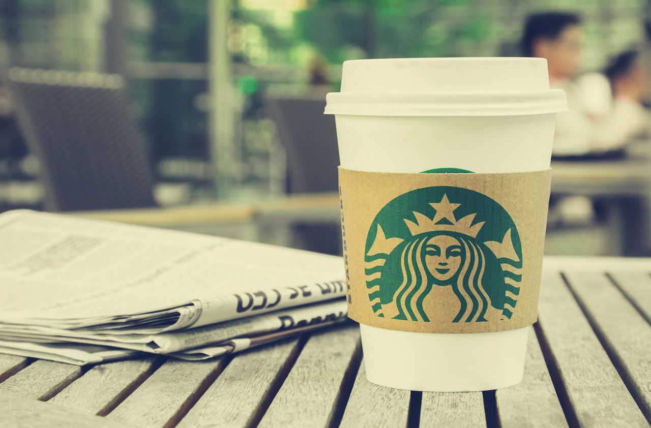 Bangkok, Thailand - Feb 26, 2015 : Starbucks coffee cup on the table in Starbucks coffee shop, Starbucks brand is one of the most world famous coffeehouse chains from USA. (vintage style colo