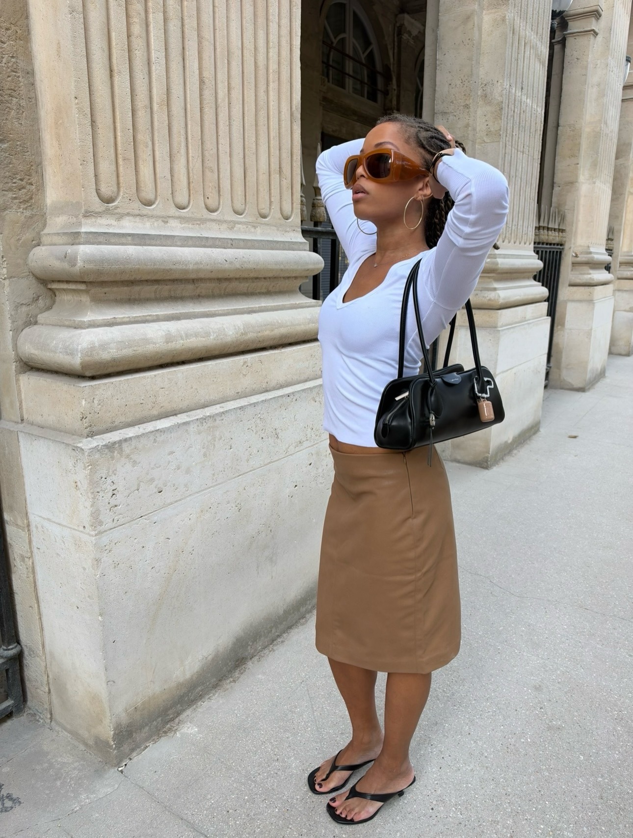 Woman in a white top and 90s midi skirt.