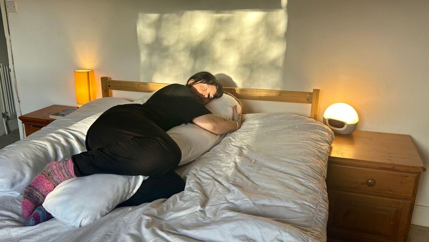 The Tom&#039;s Guide Sleep Features Editor lying on her side while using the Yana 360 Body Pillow