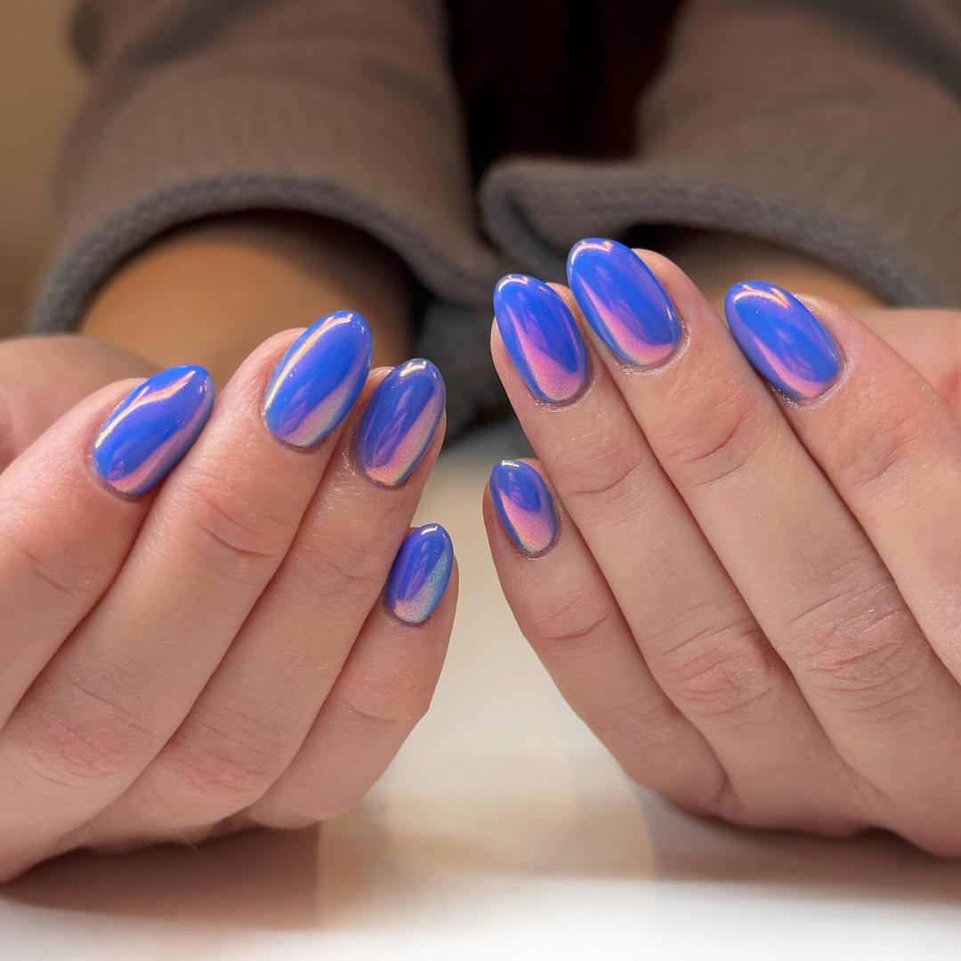a person wearing blue chrome nails